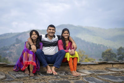 Portrait of smiling young woman against mountain