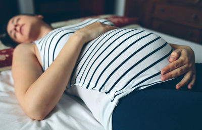 Pregnant woman lying on bed