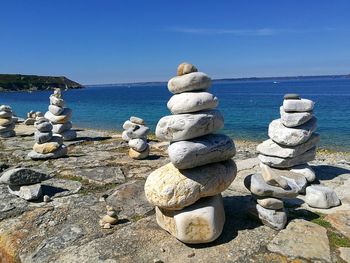 Stacked rocks against blue sky during sunny day