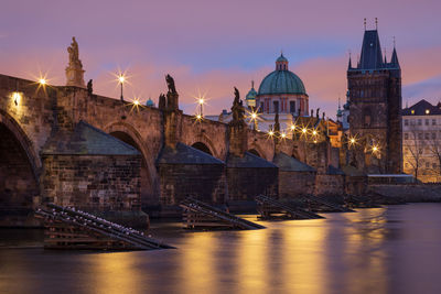 Illuminated historic charles bridge and vltava river in prague, czech republic at twilight