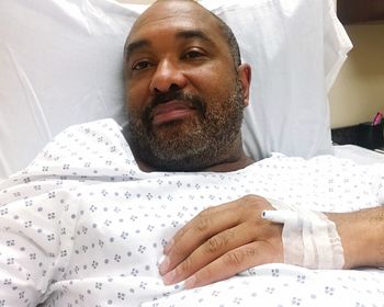 High angle portrait of male patient lying on bed in hospital