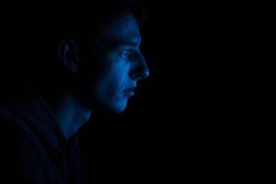 Portrait of young man against black background