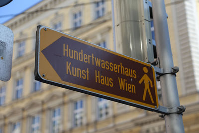 Close-up of road sign against built structure