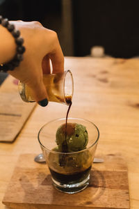 Close-up of hand pouring drink in glass