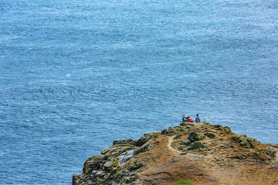 High angle view of people on rocks against sea