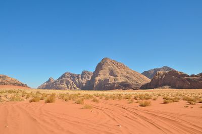 Scenic view of desert against clear blue sky