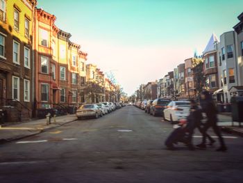 Cars on road in city against sky