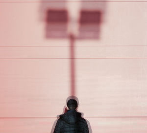 Rear view of man standing against wall