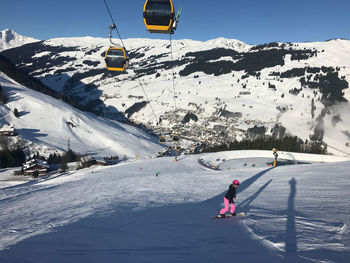 Woman snowboarding on snowcapped mountain