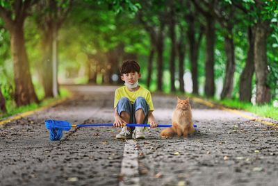 Boy with dog sitting on tree