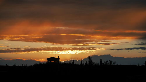 Scenic view of silhouette landscape against orange sky
