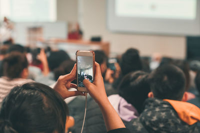 Man photographing woman using mobile phone