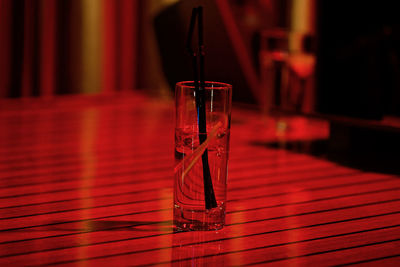 Close-up of long drink on table in red light