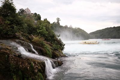 Scenic view of waterfall against sky