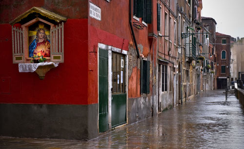 Wet street by buildings at piazza san marco during rainy season