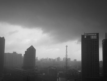 Buildings in city against cloudy sky