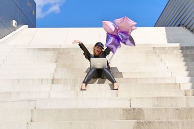 Full length of woman with umbrella on steps