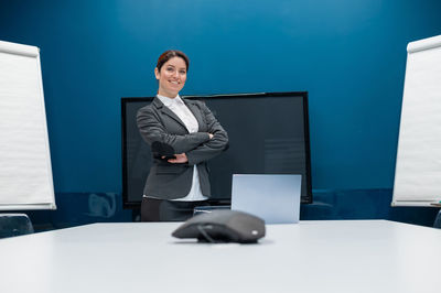 Portrait of businessman using laptop while standing in office