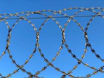 Low angle view of barbed wire against clear sky