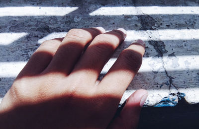 Close-up of woman hand on asphalt