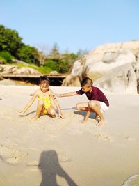 Full length of shirtless boy on land against sky