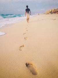 Rear view of man walking on beach