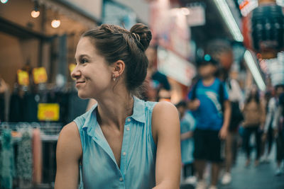 Smiling woman looking away while sitting outdoors