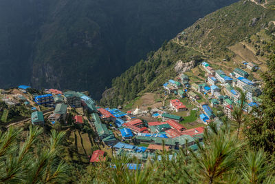 High angle view of townscape by trees on mountain