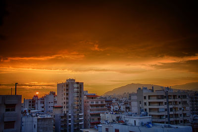 Buildings against dramatic sky during sunset