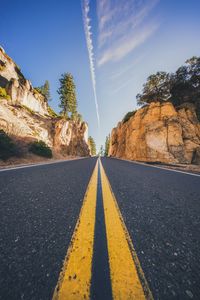 Road amidst trees against sky