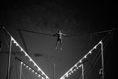 A child jumps and flies on an attraction in an amusement park against the sky. 