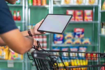 Midsection of man using digital tablet