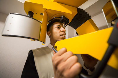 Close-up of young man using machinery