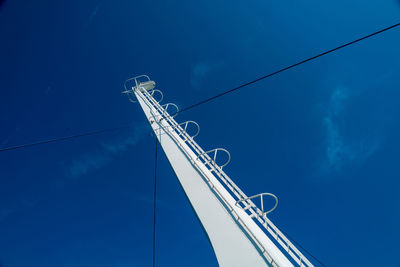 Low angle view of telephone pole against blue sky