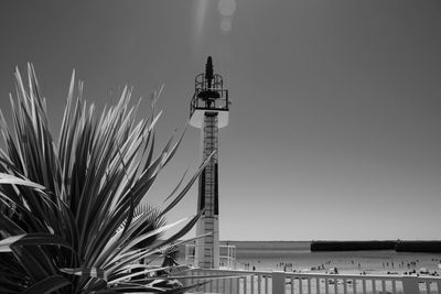 Low angle view of lighthouse by sea against clear sky
