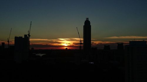 Silhouette of buildings against sky at sunset