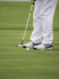 Low section of woman standing on golf ball