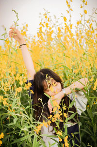 Woman standing by flowering plants on field