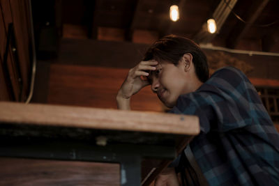 Boy with head in hand at cafe