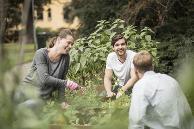 Happy friends gardening together outdoors