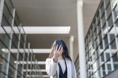 Portrait of woman standing against wall