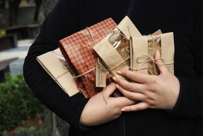 Midsection of woman holding paper