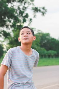 Portrait of young boy against trees