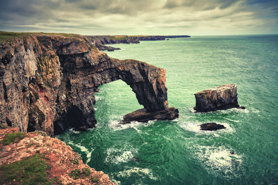 Rock formations by sea against sky