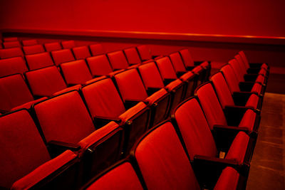 Bright red auditorium with rows of empty red cloth covered seats