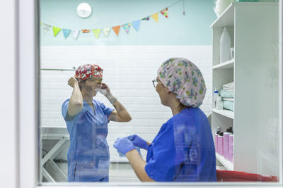 Healthcare workers in uniform and hair caps working in veterinary clinic