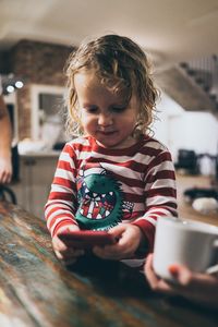 Close-up of smiling girl holding ice cream at home