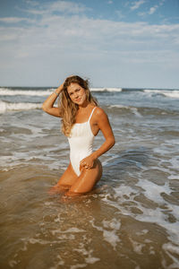 Portrait of young woman standing at beach