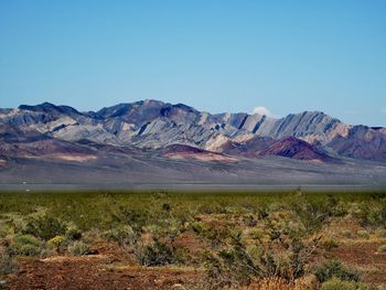 Scenic view of landscape and mountains against clear blue sky