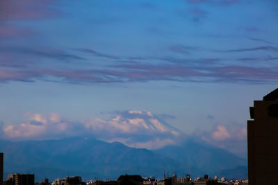 Buildings in city against cloudy sky